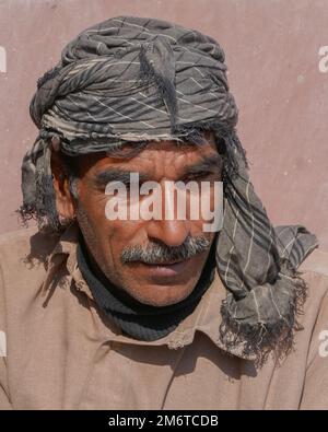 Lahore, Punjab, Pakistan - 01 27 2019 : gros plan portrait en plein air d'un homme du punjabi d'âge moyen en plein soleil portant un foulard noir et blanc Banque D'Images