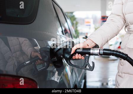 Femme pompant de l'essence dans la voiture à la station-service. Concept d'augmentation du prix de l'essence ou de l'essence. Banque D'Images