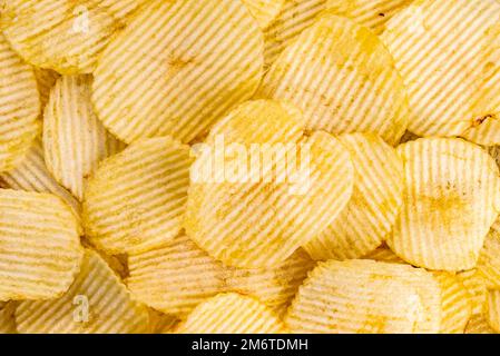 Vue de dessus des chips de pommes de terre ondulées frites et salées. Banque D'Images