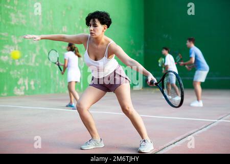 Femme jouant frontenis sur le terrain de pelota extérieur Banque D'Images