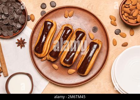 Composition avec assiette d'eclaloires savoureuses, lait, gouttes de chocolat et noix d'amande sur fond de couleur Banque D'Images