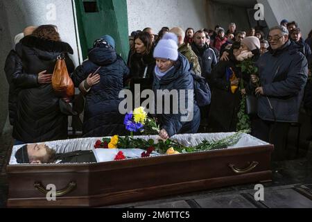 Kiev, Ukraine. 05th janvier 2023. (NOTE DE L'ÉDITEUR: L'image dépeint la mort) Une femme pose des fleurs sur le cercueil avec le corps du soldat ukrainien Viktor Onysk, qui est mort dans le combat contre l'armée russe, lors d'une cérémonie d'adieu à Kiev. (Photo par Oleksii Chumachenko/SOPA image/Sipa USA) crédit: SIPA USA/Alay Live News Banque D'Images