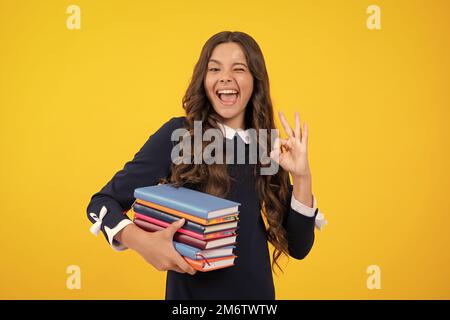 Visage excité. Adolescente avec des livres. Écolière étudiante. Expression stupéfaite, gaie et heureuse. Banque D'Images