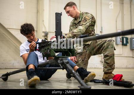 Un Airman affecté à l'escadron 19th des forces de sécurité fournit un aperçu des armes à une recrue potentielle lors d'une tournée à la base aérienne de Little Rock, Arkansas, 5 mai 2022. L'événement de recrutement, connu sous le nom de AIM High, a offert aux futurs aviateurs la chance de visiter la base et d'en apprendre davantage sur le style de vie militaire et les diverses possibilités de carrière dans la Force aérienne. Banque D'Images