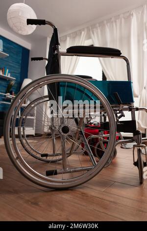 Chambre d'hôpital vide avec fauteuil roulant pour transporter un patient à mobilité réduite. Aucun patient dans la chambre de la maison de soins sociaux, de réadaptation professionnelle spécialisée et de soins quotidiens. Banque D'Images