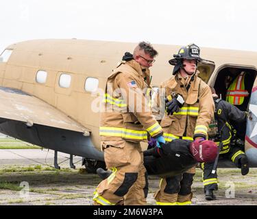 Les pompiers de l'escadron du génie civil 788th portent une victime fictive à la sécurité, 5 mai 2022, lors d'un exercice de victimes massives à la base aérienne Wright-Patterson, Ohio. L'exercice comportait un accident d'avion factice et a donné aux premiers intervenants l'occasion de s'exercer à coordonner les procédures d'intervention d'urgence. Banque D'Images