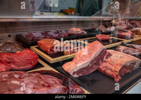 Vue de face de la viande fraîche brute de bonne qualité à travers un verre de comptoir à la boucherie. Banque D'Images