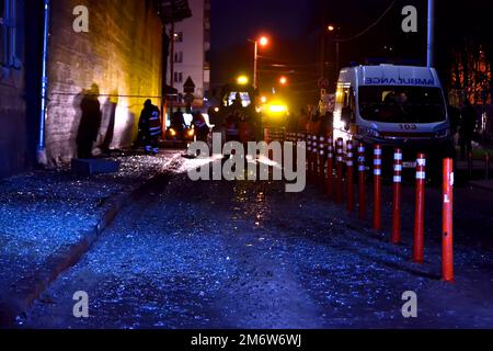 Les travailleurs délochent la rue de morceaux de verre près d'un immeuble résidentiel détruit après l'attaque de missiles sur 31 décembre 2022 à Kiev, en Ukraine. Banque D'Images