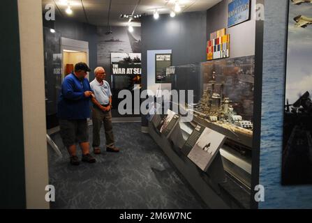 Gary Royse (à droite), un docien bénévole au Musée naval de Hampton Roads, pose des questions à un visiteur de leur galerie, vendredi, 6 mai 2022. Le musée, situé au deuxième étage du campus de Nauticus dans le centre-ville de Norfolk, en Virginie, abrite un solide corps de bénévoles qui aide le musée à relier les visiteurs à l'histoire navale de Hampton Roads, dans la région de Virginie. Banque D'Images