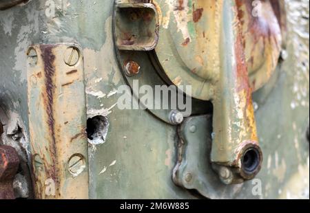 Guerre en Ukraine, un trou dans l'armure du BMP, armure percée. Texture de camouflage vert métal blindé avec dégâts et trous. Banque D'Images