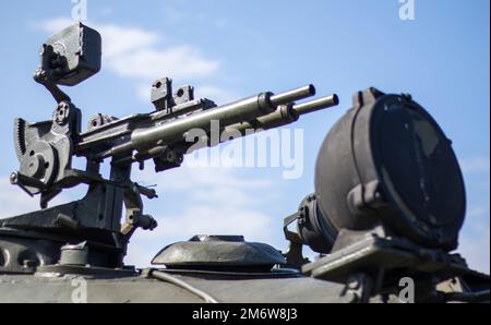 Mitrailleuse sur la tourelle d'un support personnel blindé. Armes lourdes de guerre, fond bleu ciel. Équipement militaire pour le combat Banque D'Images