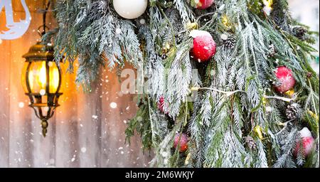 Décorations de Noël extérieures faites de branches naturelles d'épinette, de jouets, de guirlandes et d'une lanterne brillante Banque D'Images