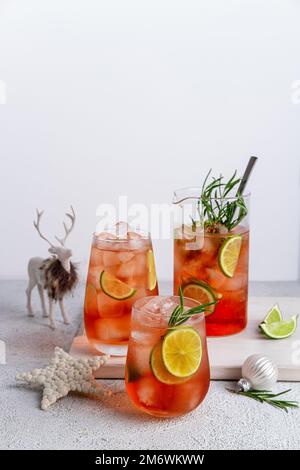 Melon d'eau et punch au citron vert. Cocktails de Noël colorés en verres sur table blanche. Boissons fraîches de vacances. Banque D'Images