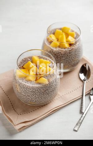 Pudding à la noix de coco au chia vegan à la mangue sur fond blanc. Nutrition saine, superalimentation. Vue en gros plan. Banque D'Images