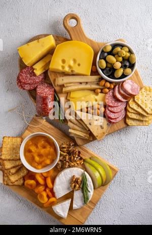 Différents types de fromages et de viandes froides. Vue de dessus sur fond blanc. Assortiment de fromages aux noix, craquelins, olives, sa Banque D'Images