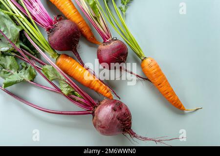 Récolte fraîchement botte. Légumes frais de ferme sur fond pastel. Aliments biologiques sains, carottes crues et betteraves Banque D'Images