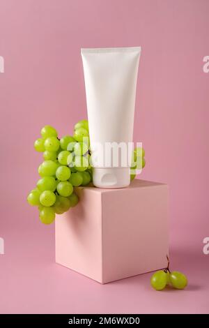 Bouteille maquette blanche pour la marque avec de l'huile de pépins de raisin sur le podium. Produit cosmétique pour le soin de la peau. Banque D'Images