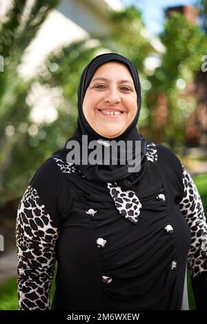 Elle aime son héritage. Portrait d'une femme musulmane mature debout à l'extérieur. Banque D'Images