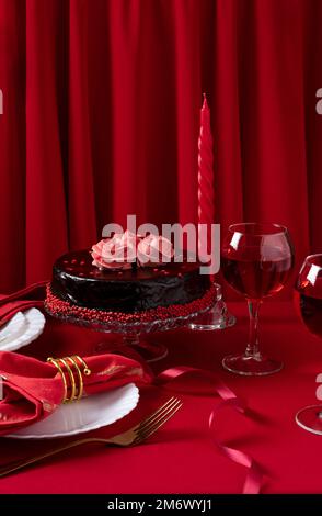 Table romantique avec vaisselle blanche et serviettes rouges, vin et bougies. Concept Saint Valentin ou dîner romantique. Romain Banque D'Images