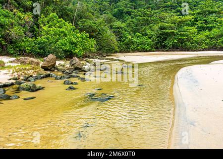 Rivière avec eau qui coule sur la plage de sable vers la mer à Trindade Banque D'Images