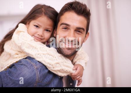 Shes Daddys petite princesse. un père donnant à sa fille une promenade en porcgyback à la maison. Banque D'Images