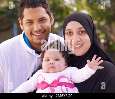 C'est notre petit enfant spécial. Une famille musulmane appréciant une journée dehors. Banque D'Images