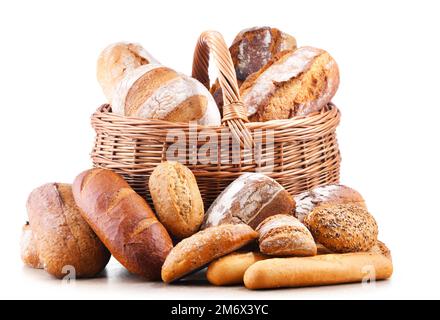 Panier en osier avec assortiment de produits de boulangerie, dont des pains et des petits pains sur fond blanc Banque D'Images