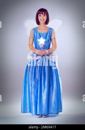 Prêt à accorder vos souhaits. Une photo en longueur d'une fillette de fées dans une robe bleue. Banque D'Images