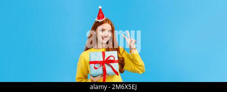 Portrait à la taille de la jolie femme heureux redhead recevoir le cadeau dans une boîte emballée, célébrant les vacances de noël, portant le nouveau yea fantaisie Banque D'Images