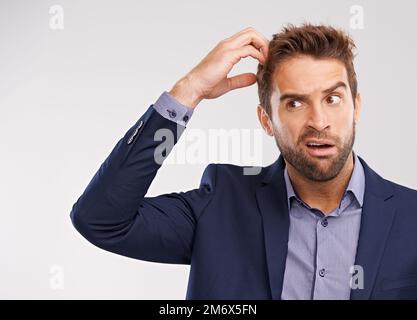 Ce qui l'a laissé complètement déconcerté. Studio photo d'un homme beau avec une expression confuse. Banque D'Images