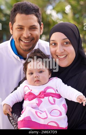 Un petit lot de joie riant. Portrait d'une famille musulmane profitant d'une journée dehors. Banque D'Images