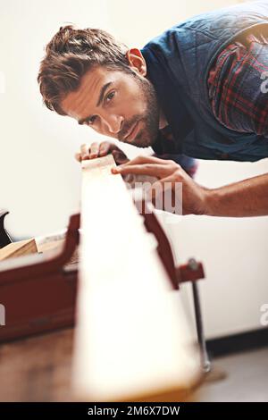 Tout droit. un charpentier travaillant sur une planche de bois dans son atelier. Banque D'Images