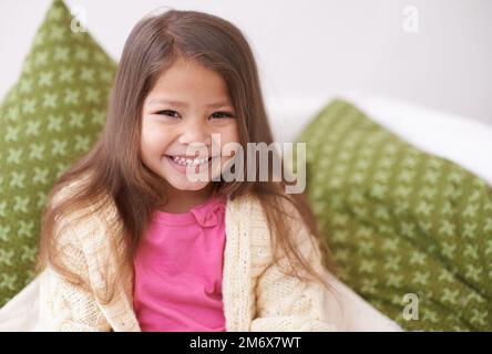 Ici, shes la princesse. Portrait d'une petite fille mignonne assise sur un canapé à la maison. Banque D'Images