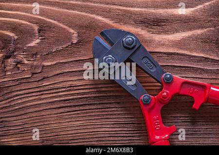 Coupe-boulons noir et rouge sur bois concept de construction Banque D'Images