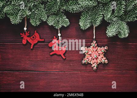 Décorations traditionnelles des fêtes d'hiver, fond de noël avec bordure en brindilles d'épicéa, décorations en forme de déers et de flocons de neige Banque D'Images