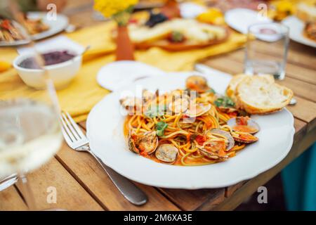 Spaghetti aux fruits de mer avec coquillages, crevettes, calmars sur fond de table. Banque D'Images