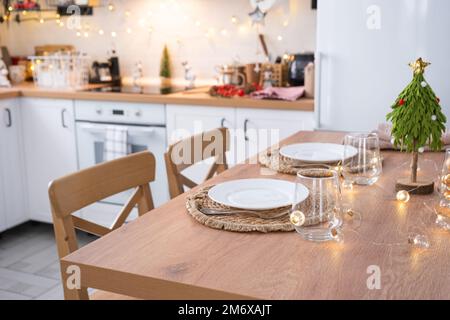 Décoration de Noël festive et mess dans la cuisine lumineuse, petit déjeuner festif, intérieur blanc de scandi. Nouvel an, ambiance, maison confortable Banque D'Images