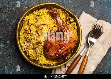 Plat indien poulet Biryani avec riz basmati dans un ancien bol en laiton métallique sur la table Banque D'Images