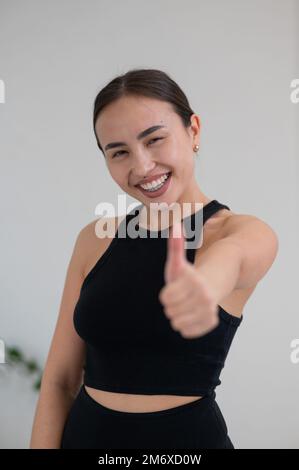 Portrait de la belle femme asiatique montrant le pouce vers le haut. Banque D'Images