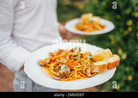 Spaghetti aux fruits de mer avec coquillages, crevettes, calmars sur fond de table. Banque D'Images