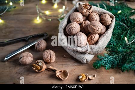 Des noix de noël festives dans un sac en toile de jute Banque D'Images