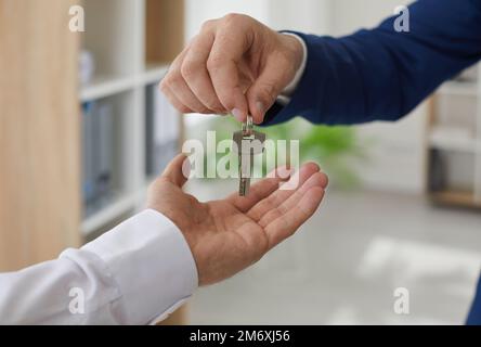 Agent immobilier qui remet les clés au propriétaire d'une nouvelle maison ou d'un nouvel appartement Banque D'Images