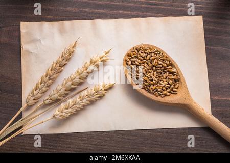 épis de blé et cuillère en bois wtih corns sur papier vintage et de la nourriture de planche et de boisson concept Banque D'Images