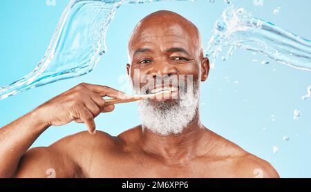 Homme noir, hygiène dentaire et brosse à dents avec eau, bien-être et hygiène sur fond bleu studio. Santé bucco-dentaire, Afro-américain et Banque D'Images