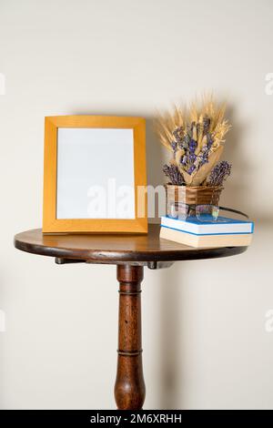 table sur pied intérieure mockup style de vie avec cadre photo vide panier de livres et de lunettes de fleurs séchées Banque D'Images