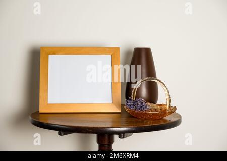 table sur pied intérieure mockup lifestyle avec vase vide pour cadre photo et panier en verre avec lavande séchée Banque D'Images