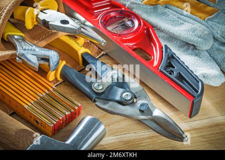 Composition de l'outillage de construction dans la ceinture à outils sur la planche en bois. Banque D'Images