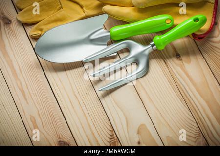 pelle à main et fourche avec gants sur bois. outils de jardin. Banque D'Images