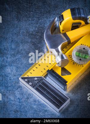 Instruments de mesure et marteau à griffe sur fond métallique rayé concept de construction. Banque D'Images