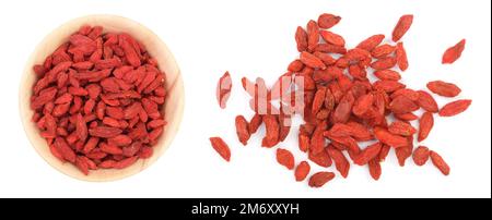 Baies de goji séchées dans un bol en bois isolées sur fond blanc Banque D'Images